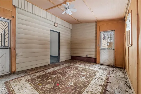 a front view of a house with a yard covered with snow and trees