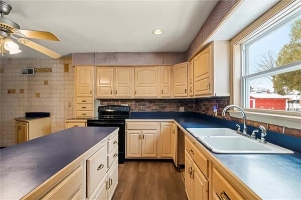 a kitchen with stainless steel appliances granite countertop sink stove top oven and cabinets