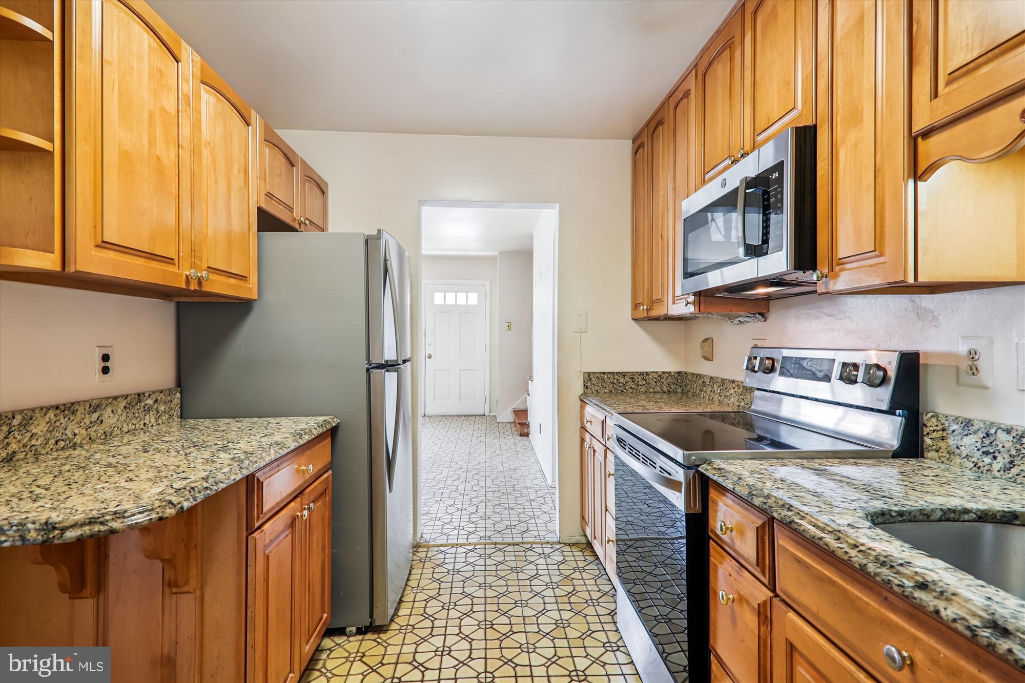 9507 Adelphi Road Silver Spring, MD 20903 - Photo 13 of 41 a kitchen with stainless steel appliances granite countertop a sink stove and refrigerator
