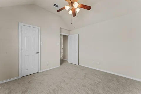 an empty room with a window and a fan