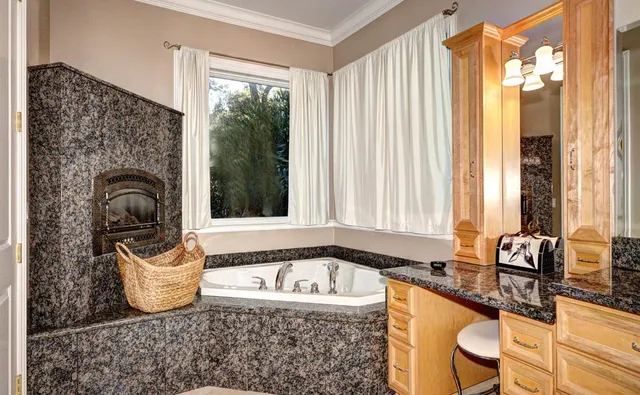 a bathroom with a granite countertop sink and a window