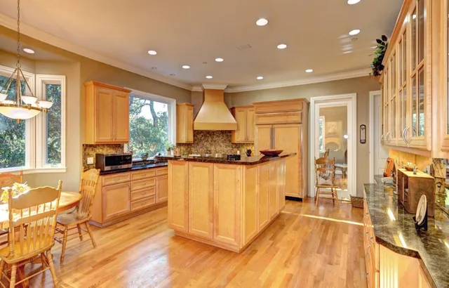a kitchen with stainless steel appliances granite countertop a refrigerator a stove and a wooden floors