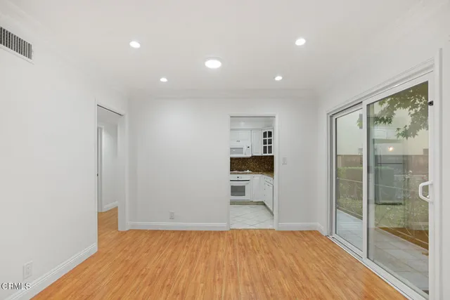 a view of empty room with wooden floor and floor to ceiling window