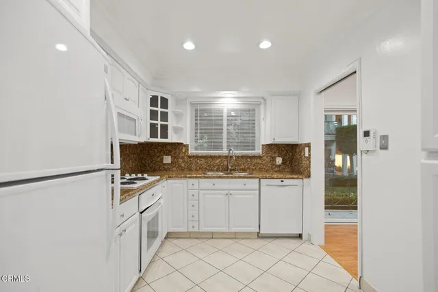 a kitchen with granite countertop a refrigerator and a sink