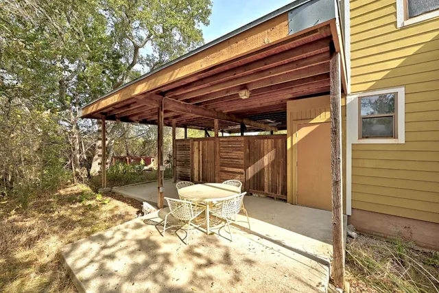 a patio with table and chairs and potted plants