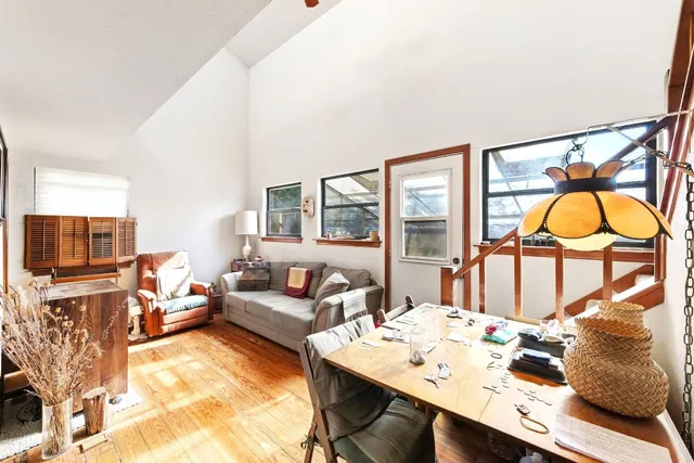 a living room with furniture a flat screen tv and a floor to ceiling window