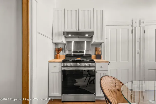 a view of a white house with a big yard and large trees