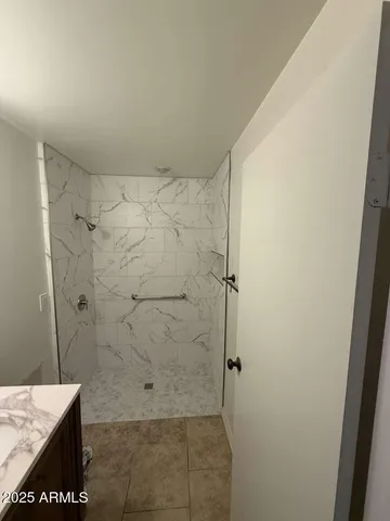 a bathroom with a granite countertop shower and a sink