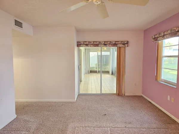 an empty room with a fireplace and windows