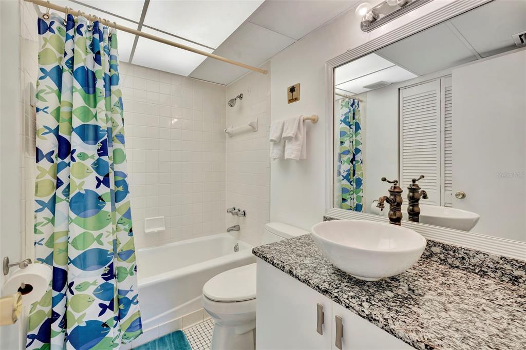 6157 Midnight Pass Road, Unit E24 Sarasota, FL 34242 - Photo 11 of 44 a bathroom with a granite countertop sink a toilet and shower