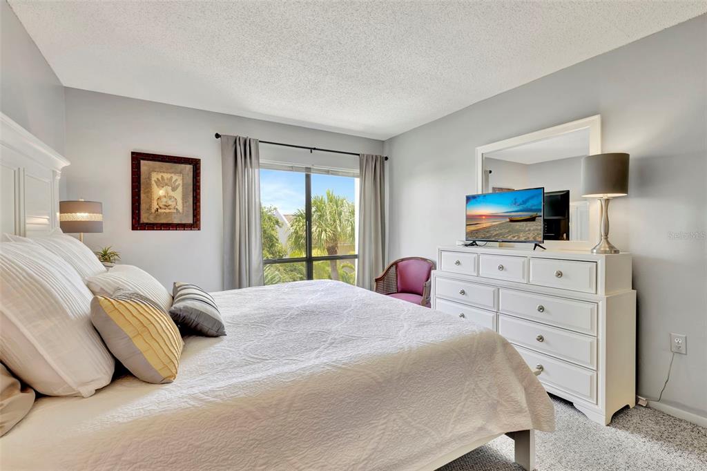 6157 Midnight Pass Road, Unit E24 Sarasota, FL 34242 - Photo 13 of 44 a bedroom with a bed and wooden floor