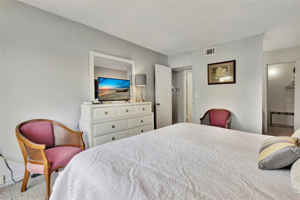 6157 Midnight Pass Road, Unit E24 Sarasota, FL 34242 - Photo 14 of 44 a bedroom with a bed and a flat screen tv