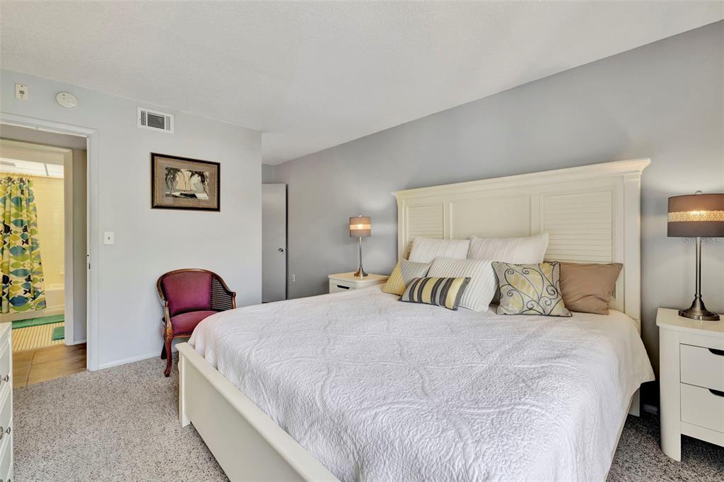 6157 Midnight Pass Road, Unit E24 Sarasota, FL 34242 - Photo 15 of 44 a bedroom with a bed and painting on the wall