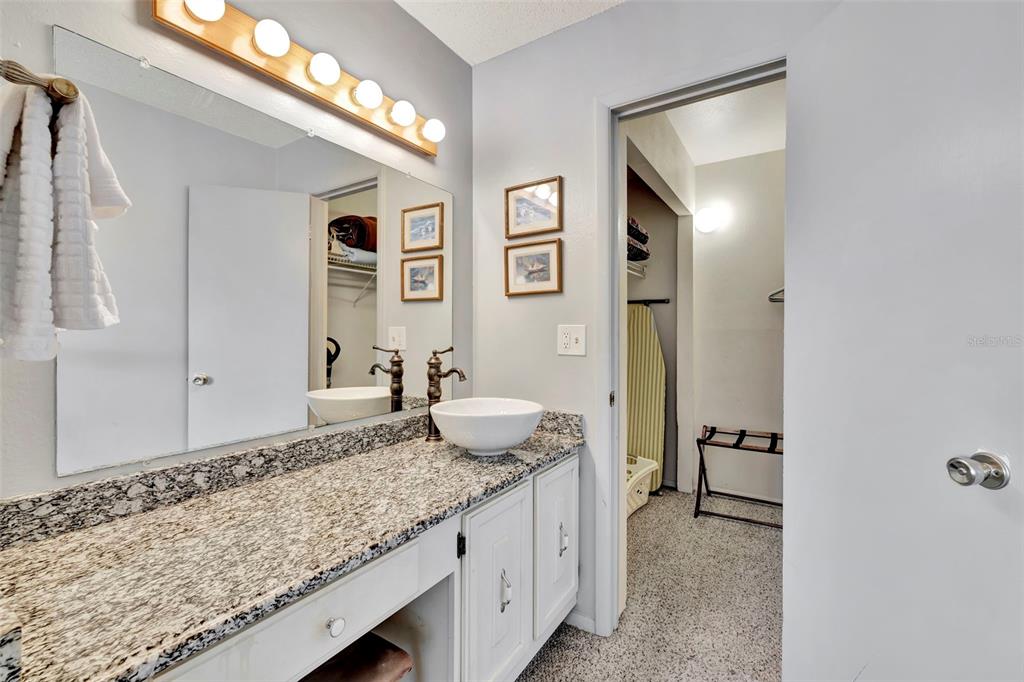 6157 Midnight Pass Road, Unit E24 Sarasota, FL 34242 - Photo 16 of 44 a bathroom with a granite countertop sink and a mirror