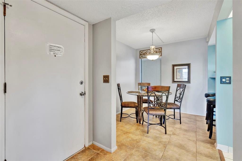 6157 Midnight Pass Road, Unit E24 Sarasota, FL 34242 - Photo 18 of 44 a view of a dining room with furniture and chandelier