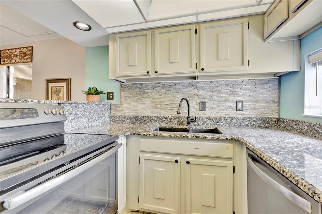 6157 Midnight Pass Road, Unit E24 Sarasota, FL 34242 - Photo 20 of 44 a kitchen with stainless steel appliances granite countertop a sink and cabinets