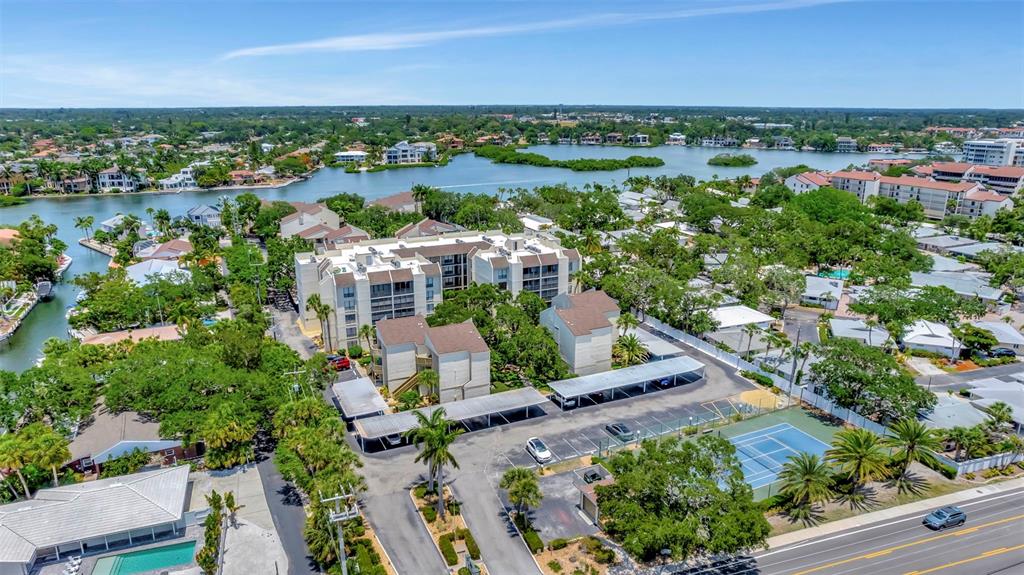 6157 Midnight Pass Road, Unit E24 Sarasota, FL 34242 - Photo 36 of 44 an aerial view of a city with lots of residential buildings ocean and mountain view in back