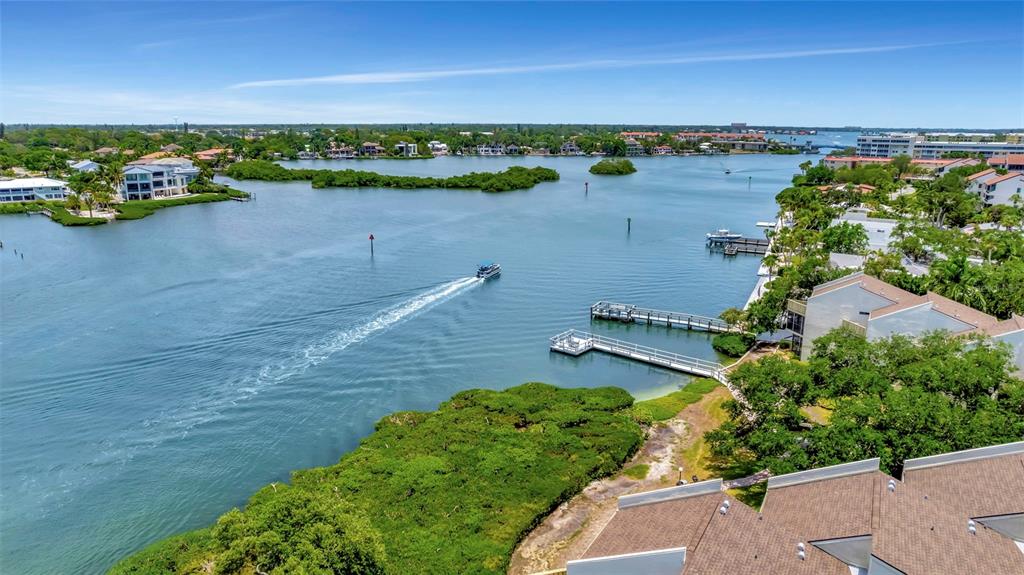6157 Midnight Pass Road, Unit E24 Sarasota, FL 34242 - Photo 40 of 44 an aerial view of a house with a yard and lake view