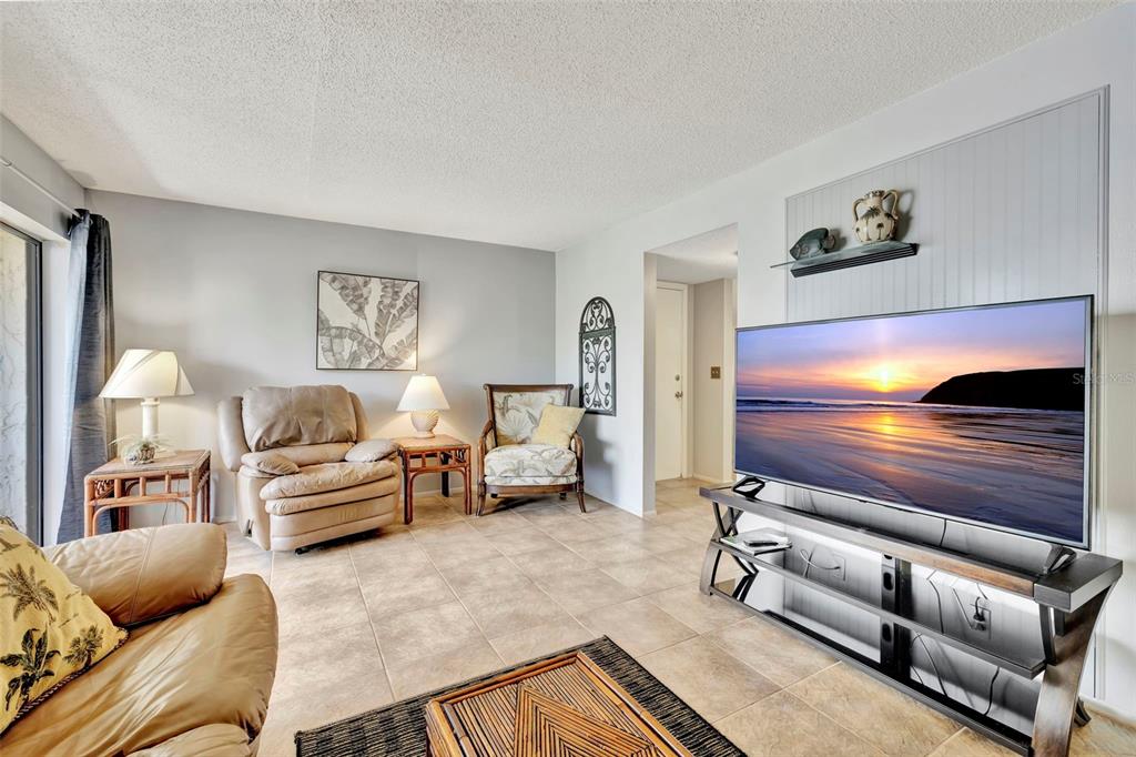 6157 Midnight Pass Road, Unit E24 Sarasota, FL 34242 - Photo 7 of 44 a living room with furniture and a lamp