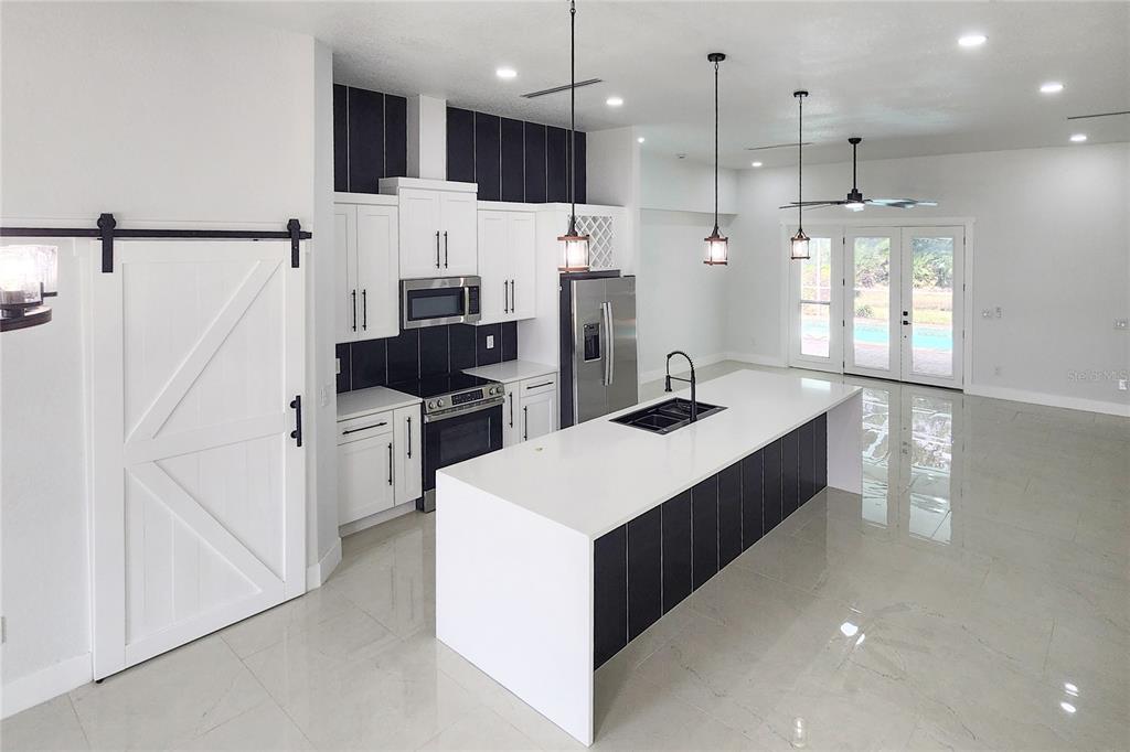 7027 Frascati Loop Wesley Chapel, FL 33544 - Photo 7 of 28 a kitchen with stainless steel appliances a refrigerator sink and microwave