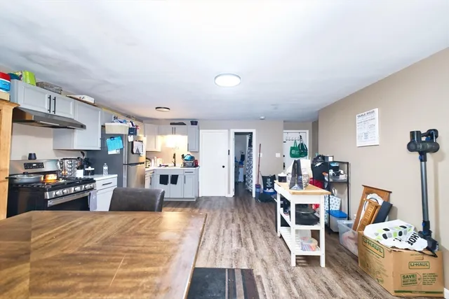 a kitchen with stainless steel appliances wooden floor dining table and chairs