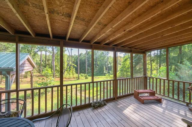 a balcony with wooden floor table and chairs