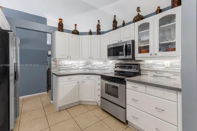 a kitchen with cabinets stainless steel appliances and a counter top space