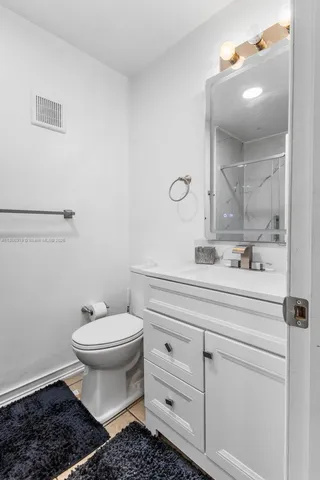 a bathroom with a sink toilet and mirror