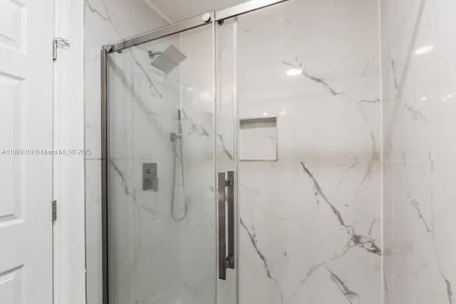 a bathroom with a shower and a glass door