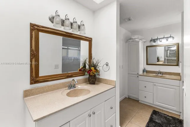 a bathroom with a sink and two mirror