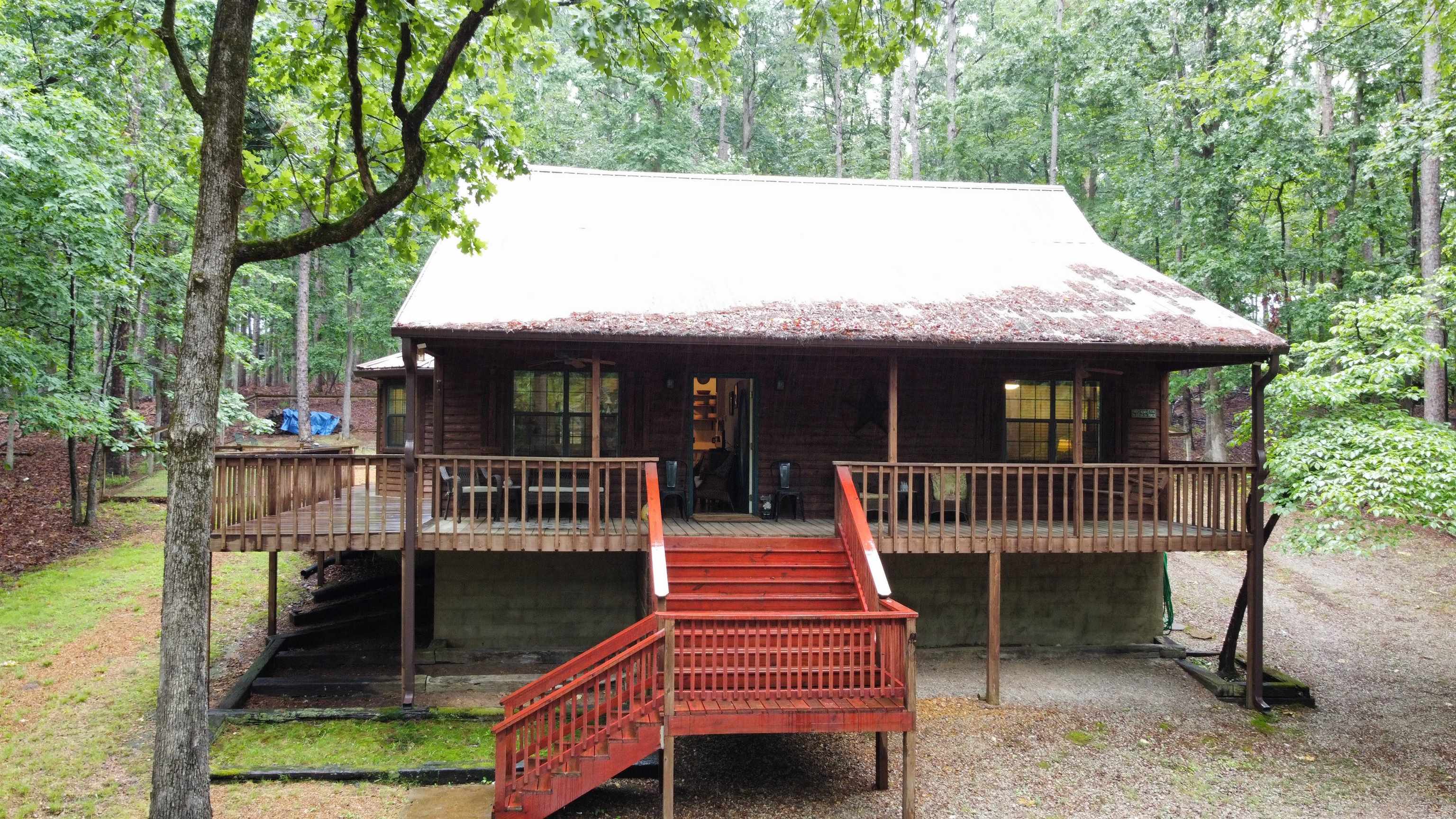 275 Bryson Harbor Road Counce, TN 38326 - Photo 2 of 23 Wood-sided residence featuring a prominent front deck with red-stained stairs and railings