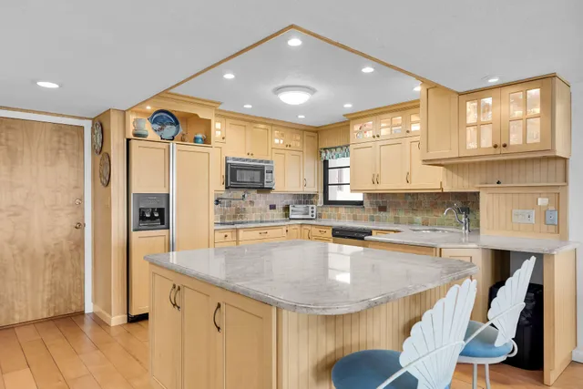 a dining room with furniture a chandelier and wooden floor