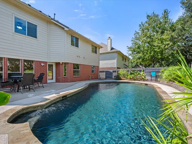a view of a house with pool and sitting area