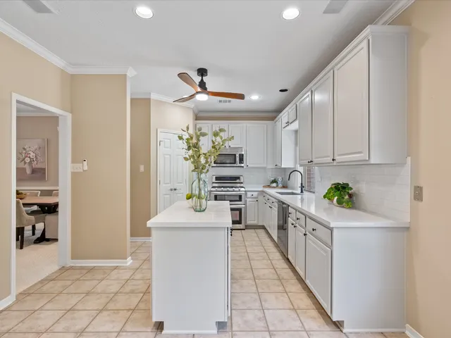 a kitchen with white cabinets and appliances