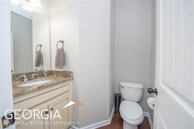 a bathroom with a granite countertop toilet sink and mirror