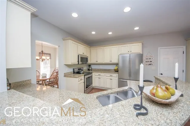 a kitchen with refrigerator and chairs