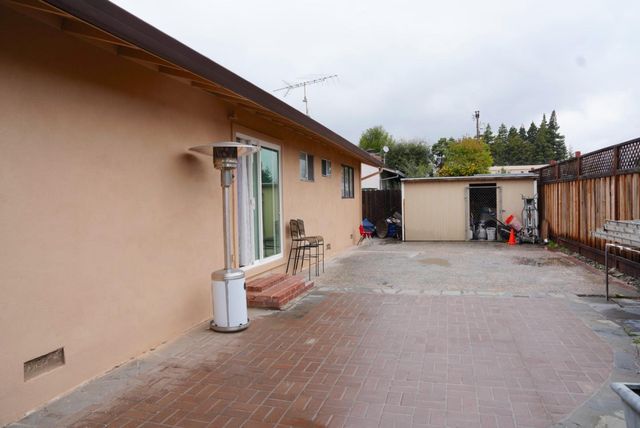 a view of a house with backyard and sitting area