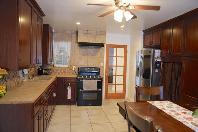a kitchen with stainless steel appliances granite countertop a sink a stove and a refrigerator
