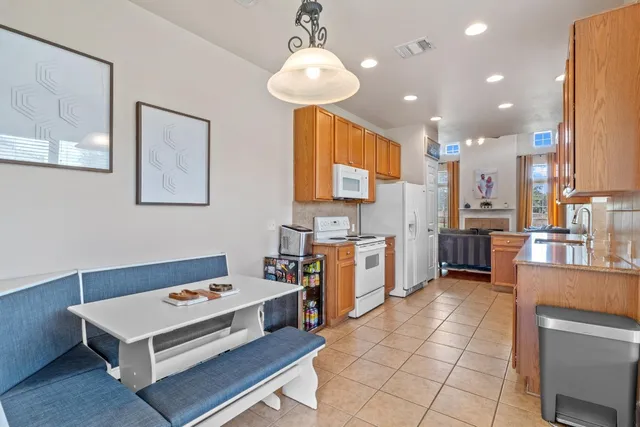 a kitchen view with stainless steel appliances kitchen island granite countertop a sink and a refrigerator