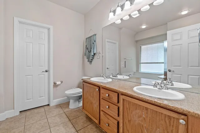 a bathroom with a granite countertop sink a toilet and a mirror