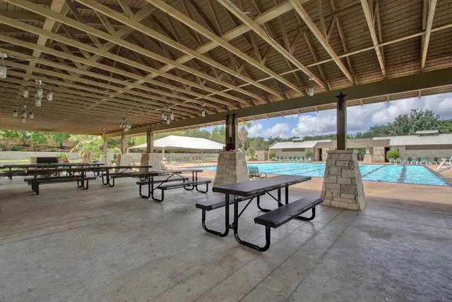 a view of a swimming pool with lawn chairs and a floor to ceiling window