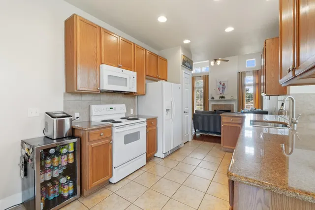 a kitchen with stainless steel appliances granite countertop a stove a sink and a refrigerator