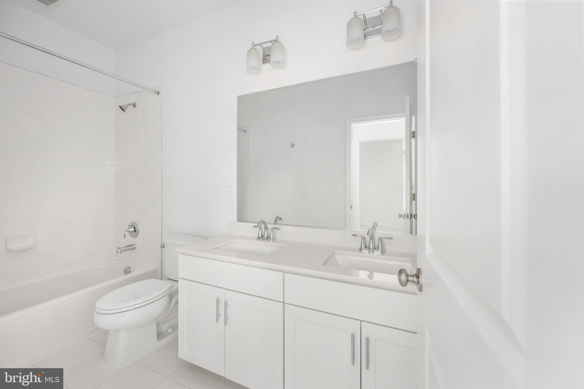 10157 Queens Way Manassas, VA 20110 - Photo 16 of 27 a bathroom with a toilet a sink a mirror a shower a vanity and window