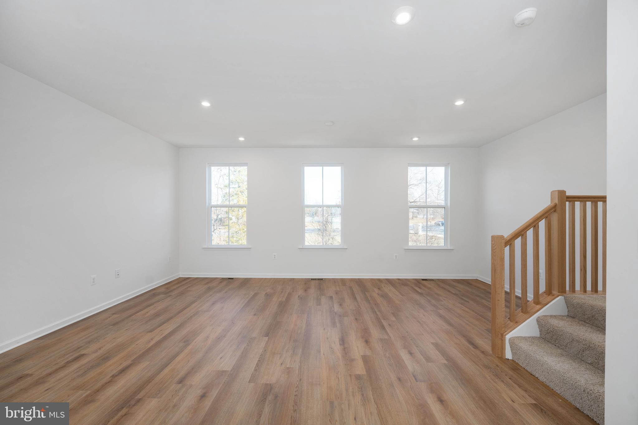 10157 Queens Way Manassas, VA 20110 - Photo 5 of 27 an empty room with wooden floor and windows