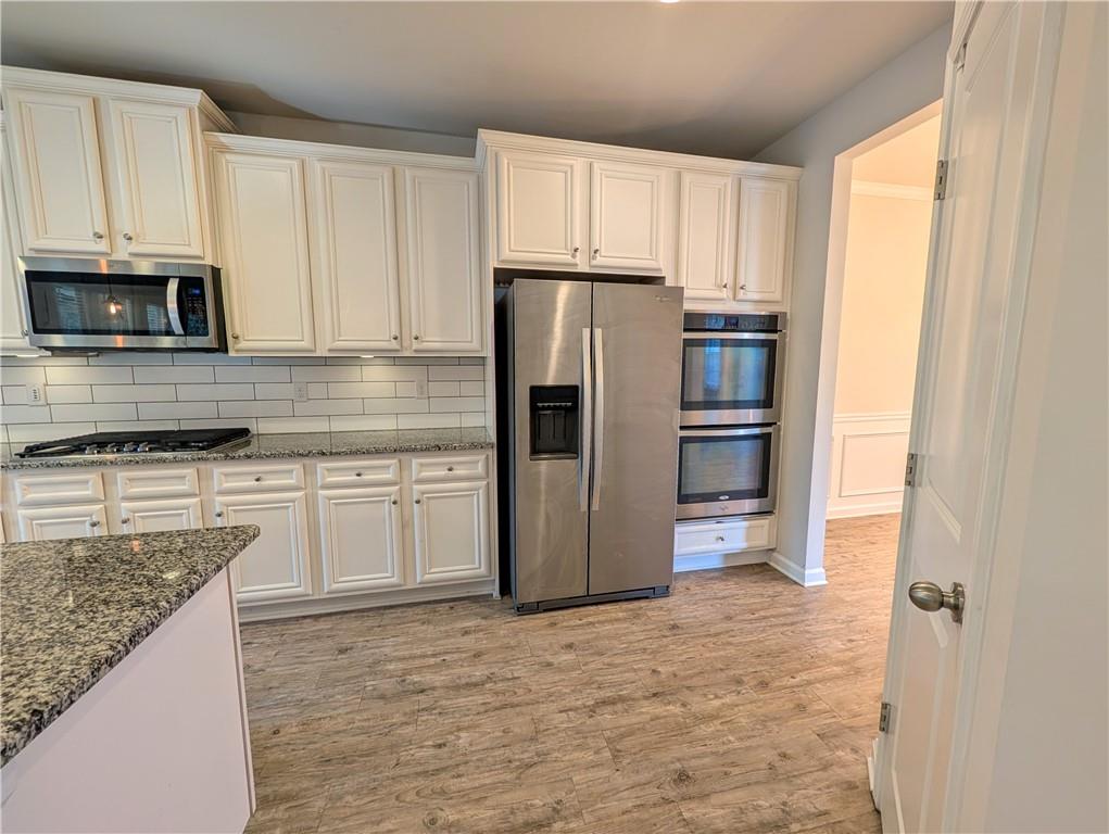 5250 Whisper Point Boulevard Cumming, GA 30028 - Photo 16 of 55 a kitchen with stainless steel appliances granite countertop a refrigerator and a stove