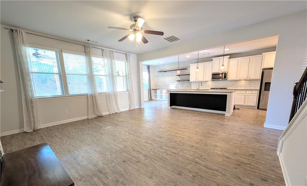 5250 Whisper Point Boulevard Cumming, GA 30028 - Photo 21 of 55 a view of kitchen with granite countertop a stove top oven a sink dishwasher a dining table and chairs with wooden floor