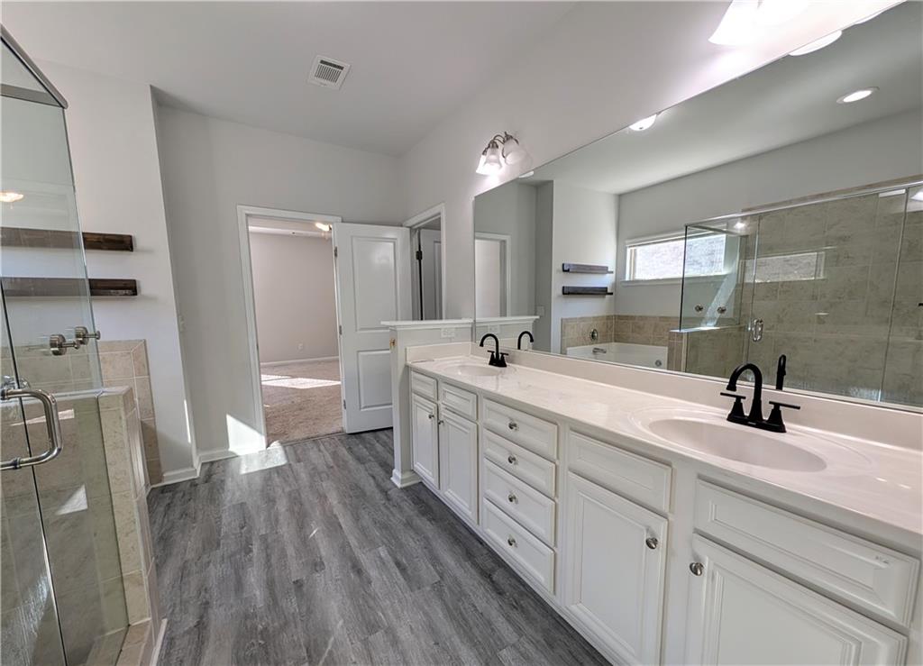 5250 Whisper Point Boulevard Cumming, GA 30028 - Photo 37 of 55 a spacious bathroom with a double vanity sink a mirror and a shower