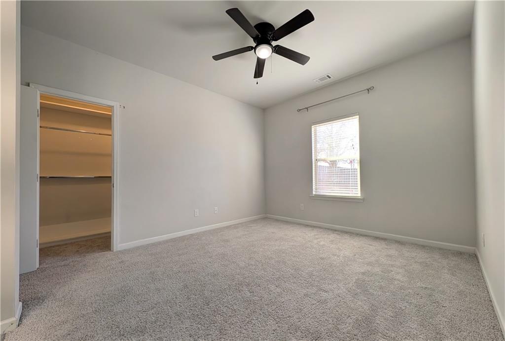 5250 Whisper Point Boulevard Cumming, GA 30028 - Photo 52 of 55 an empty room with windows and a ceiling fan