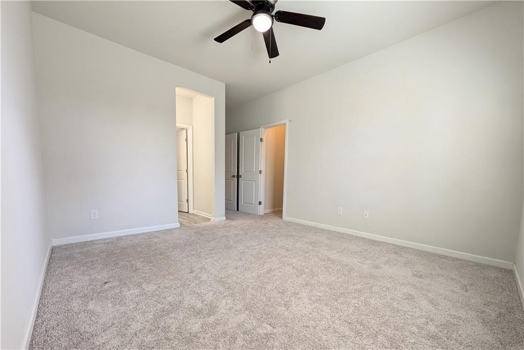 5250 Whisper Point Boulevard Cumming, GA 30028 - Photo 54 of 55 an empty room with ceiling fan and window