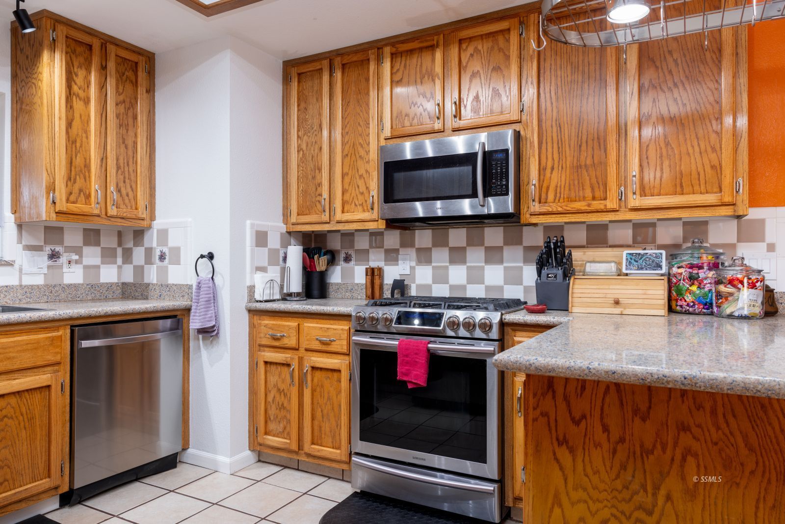 421 South Lincoln Street Ridgecrest, CA 93555 - Photo 13 of 28 a kitchen with stainless steel appliances granite countertop a stove sink microwave and cabinets